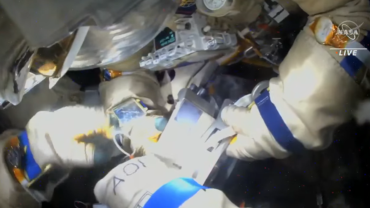 russian cosmonauts peering at items during spacewalk