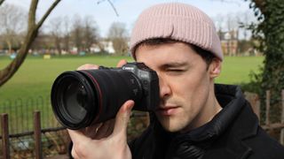 Canon EOS R8 with RF 24-70mm lens being held by our reviews editor in a park