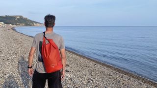 Man wearing Osprey Wildwater Dry Bag on beach