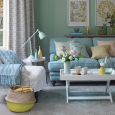 A duck egg blue living room with white armchair and blue sofa