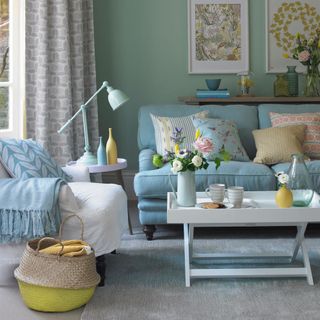 A duck egg blue living room with white armchair and blue sofa