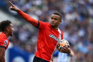 Carlton Morris of Luton Town celebrates after scoring the team's first goal from a penalty kick during the Premier League match between Brighton & Hove Albion and Luton Town at American Express Community Stadium on August 12, 2023 in Brighton, England.