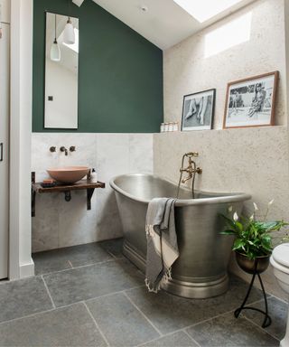 modern bathroom with stainless freestanding tub and grey natural stone tiled floor