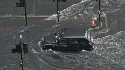 Taxi drives on flooded London street