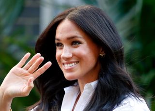 Meghan Markle on a 2018 visit to Australia wearing butterfly earrings and a white blouse