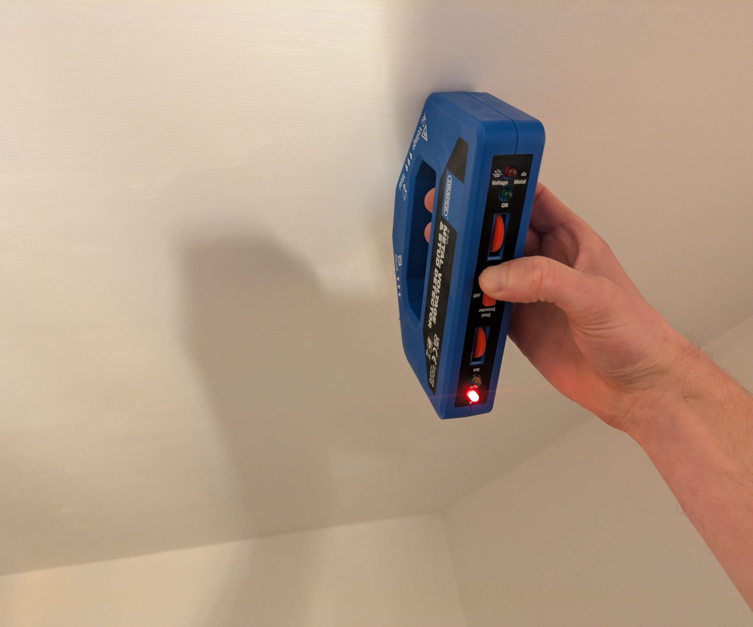 Using a wire detector to check for wires behind a ceiling surface