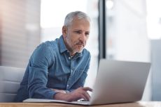 Cropped shot of a mature businessman working on a laptop in an office
