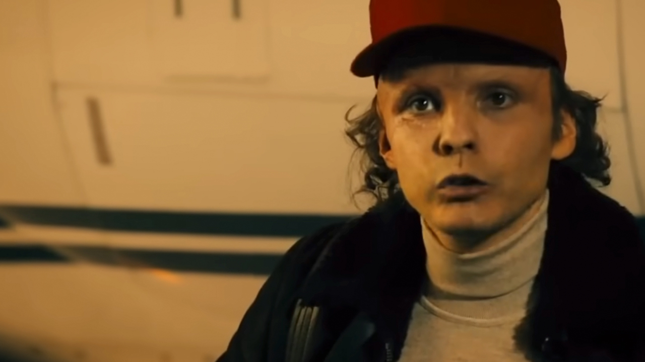 Daniel Bruhl wearing a red hat and looking serious in Rush.