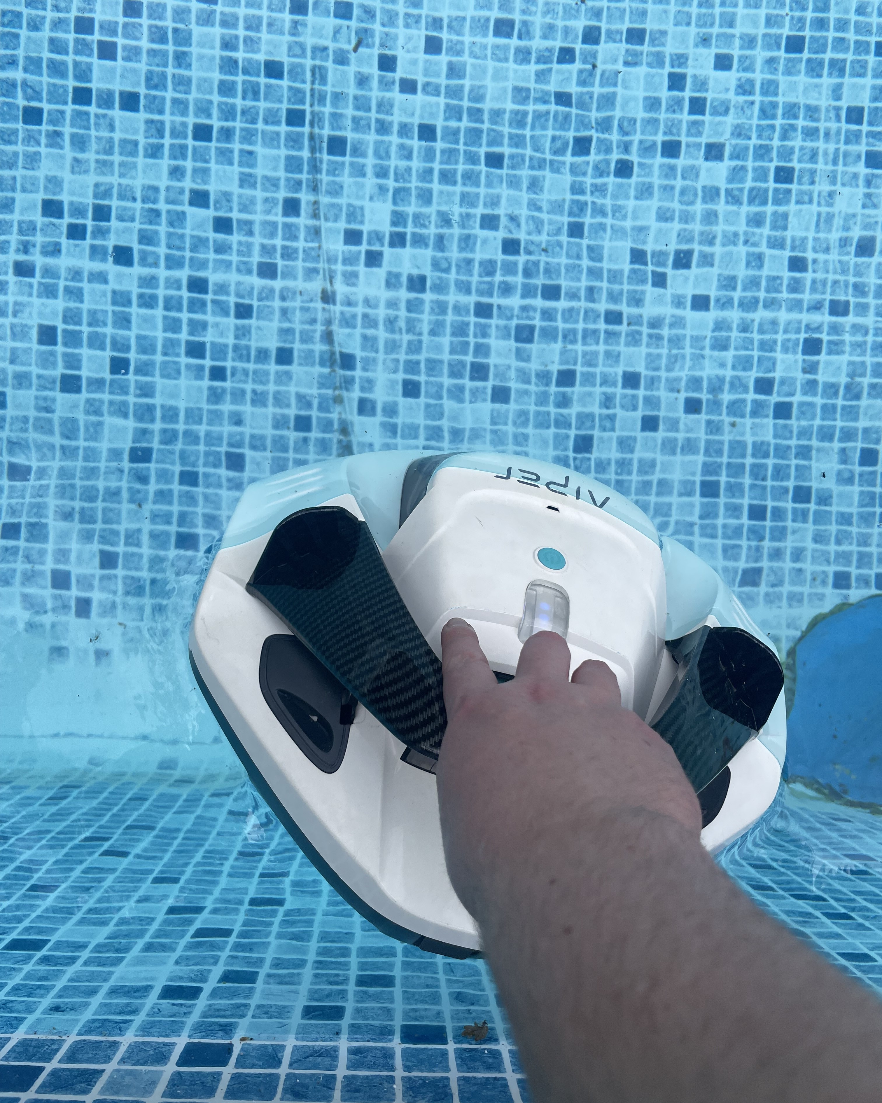 A robot pool cleaner being dropped into a pool