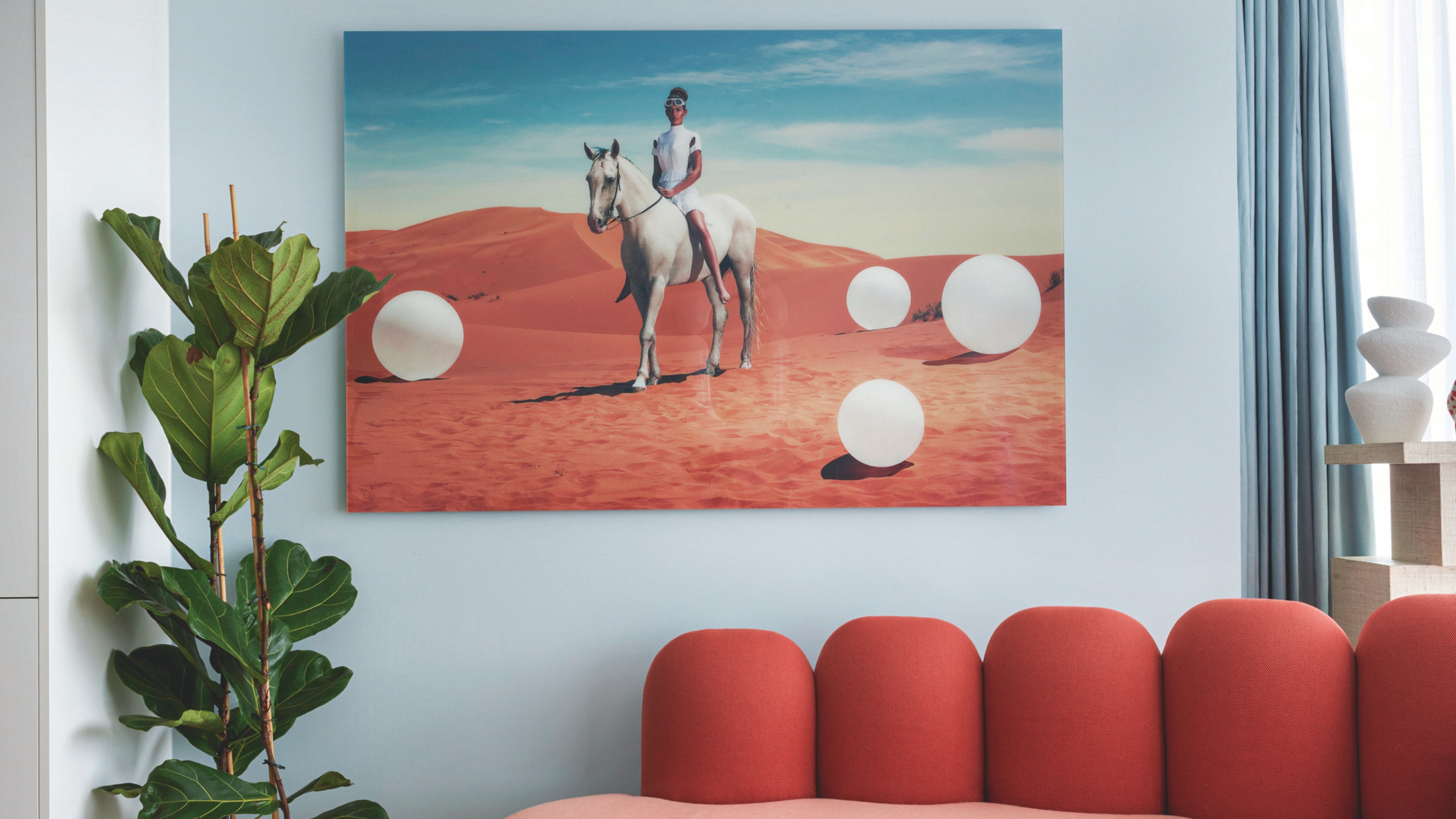 a light blue room with artwork featuring a horse in the desert