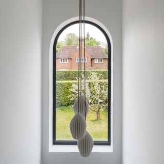 an arched window in a hallway with a pendant light