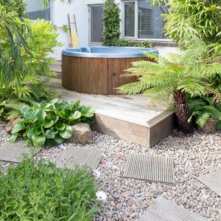 garden pathway with plants and water wooden tank
