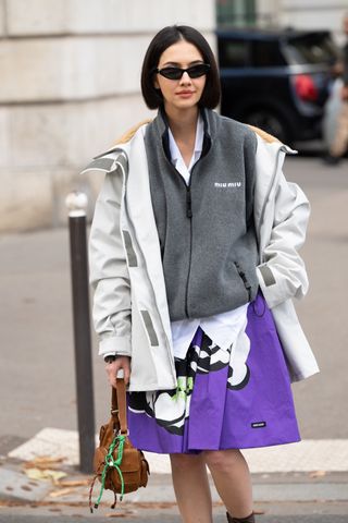 Woman in sporty jacket and skirt.