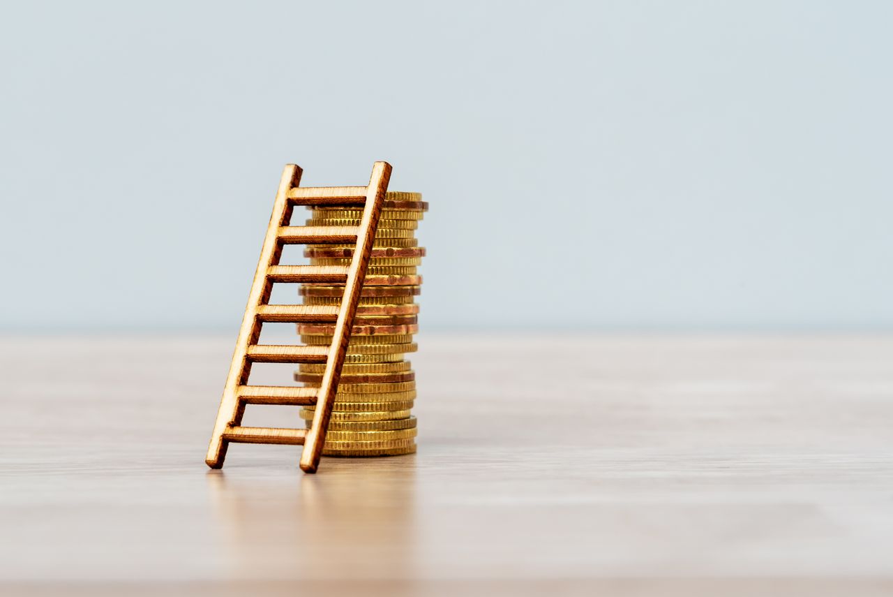 A stack of gold coins with a ladder leading up them.