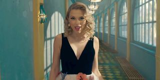 Taylor Swift walking through a blue hallway in the ME! music video for Lover album