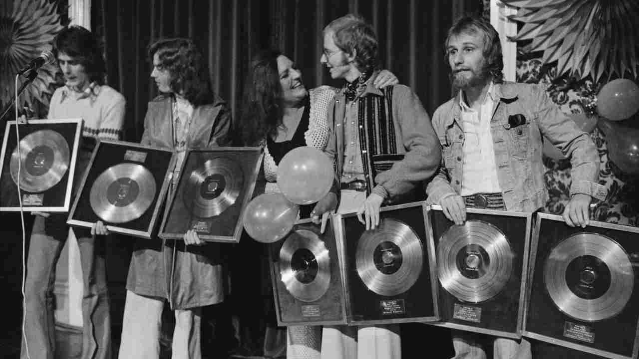 Wishbone Ash posing for a photograph with gold discs in the 1970s