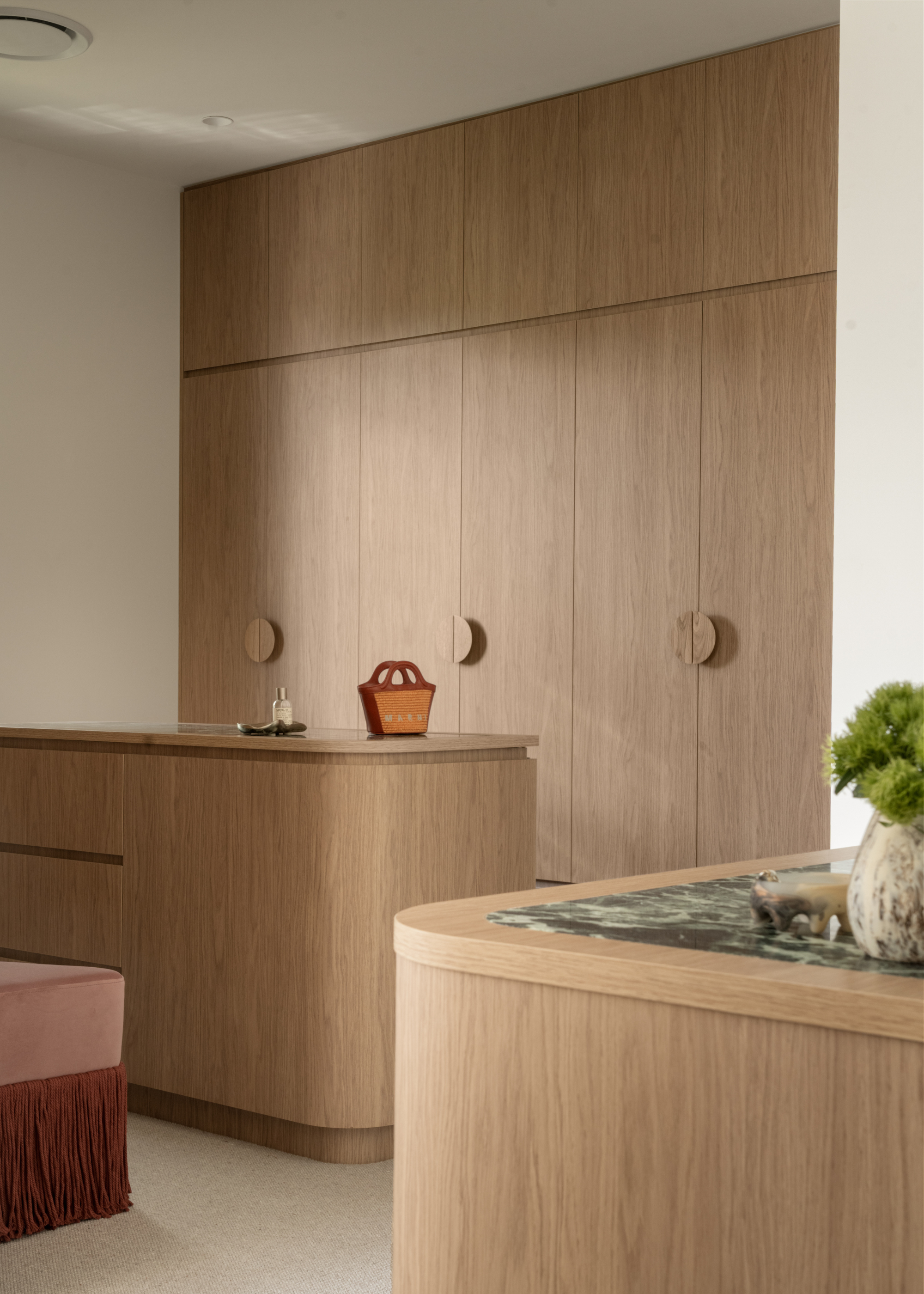 A wood wardrobe with an island and a fringe stool