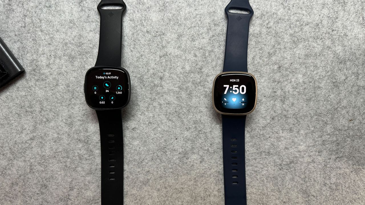 Fitbit Versa 3 and Fitbit Versa 4 laid out on plain grey background