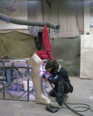 Man is working on the sculpture leg