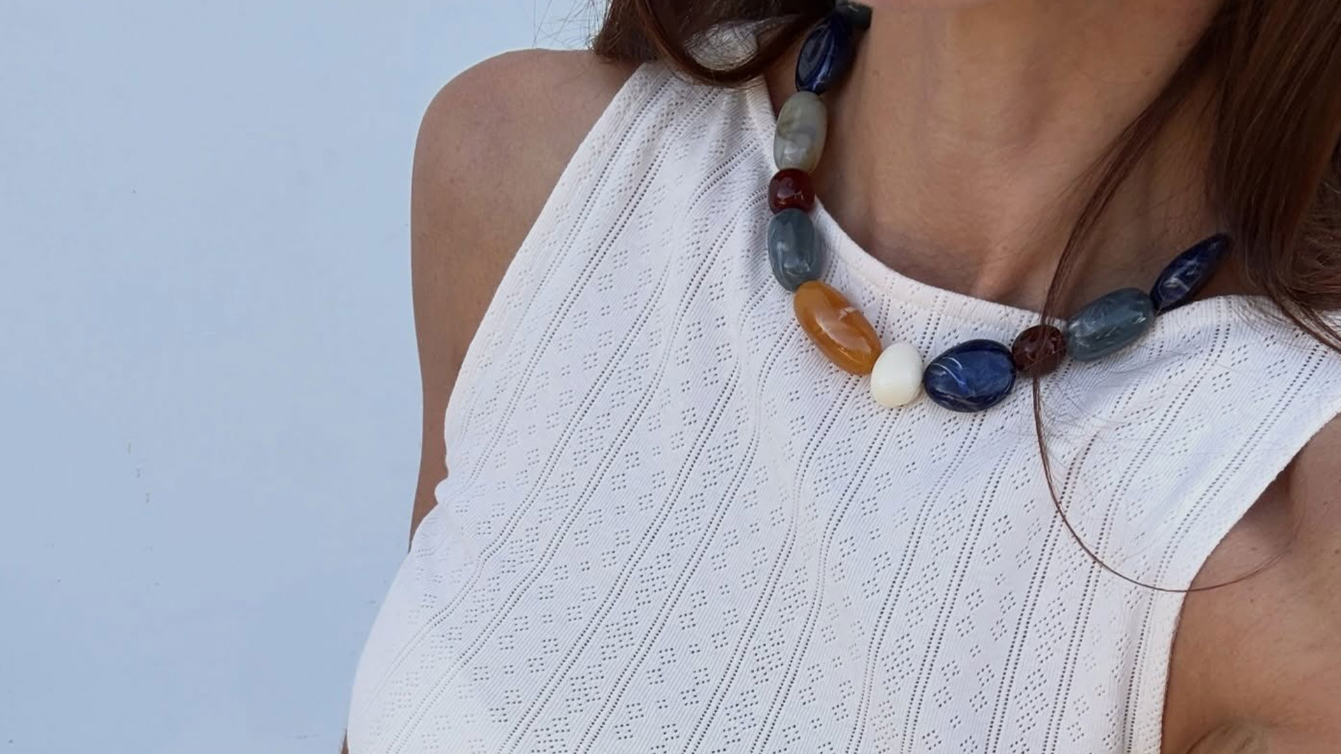 @jen_wonders close-up featuring colorful beaded necklace and cream knit tank.