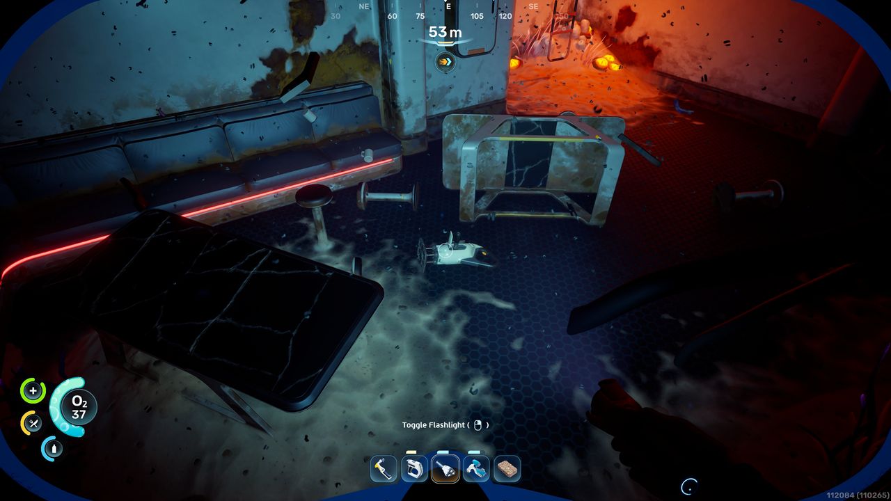 Subnautica 2 mining: A player looking at a Sonic Resonator fragment they can scan inside a dark habitat.