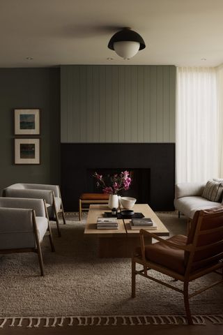 living room with sage paneling above fireplace