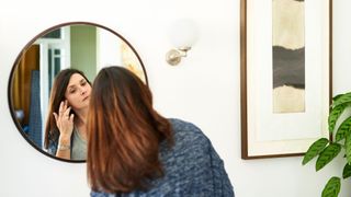 Woman getting ready for bed in round mirror