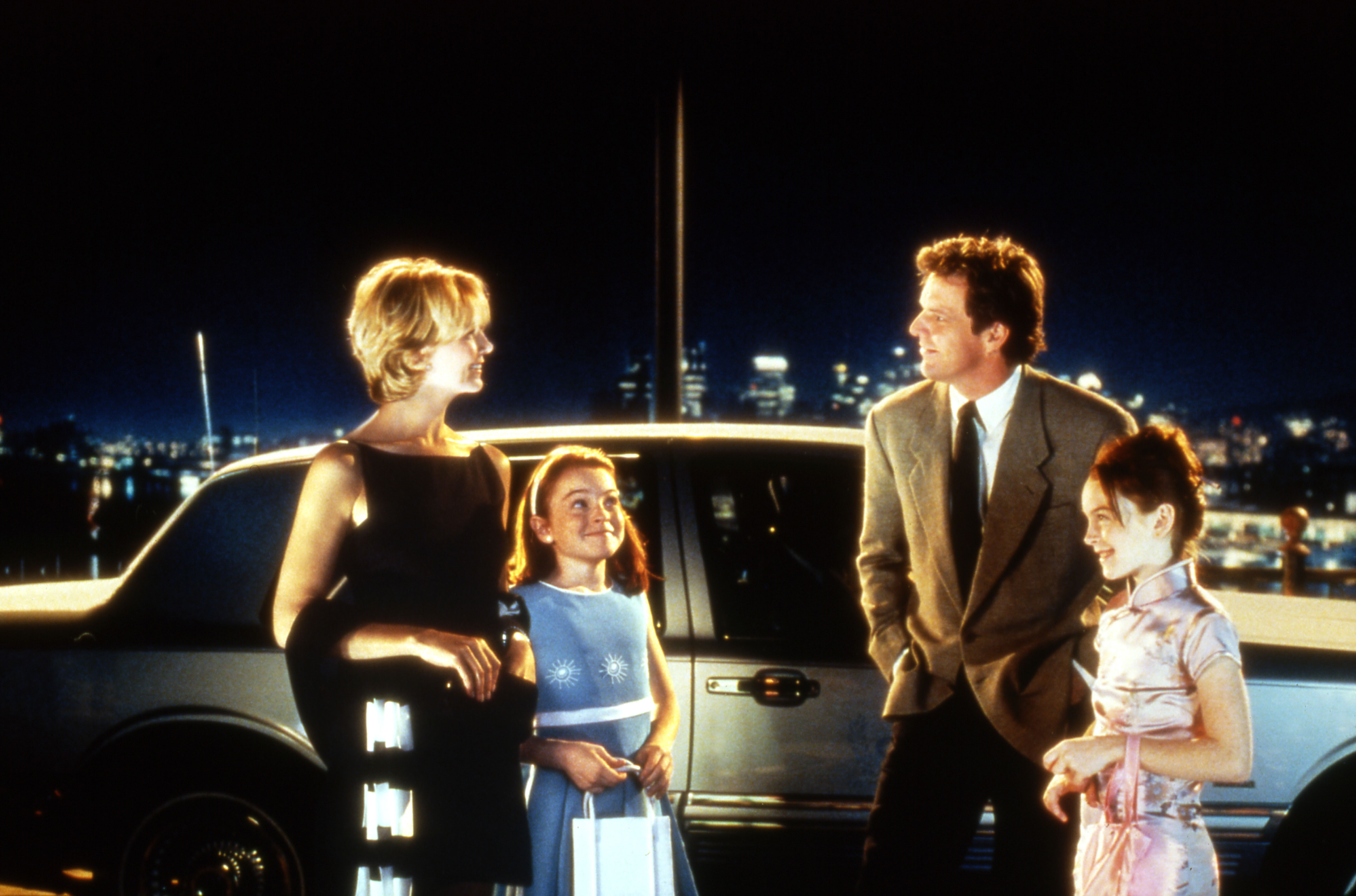 natasha richardson lindsay lohan and dennis quaid outside of a car by a skyline in the parent trap