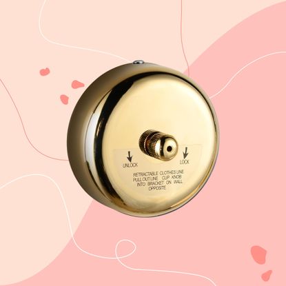 brass retractable clothes line on a pink graphic background