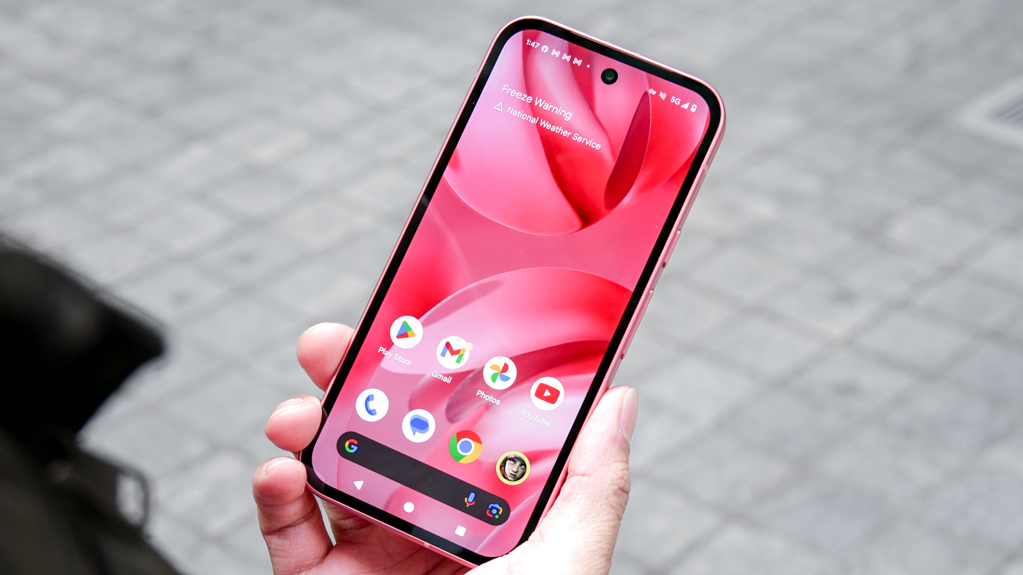 Google Pixel 9a held in the hand.