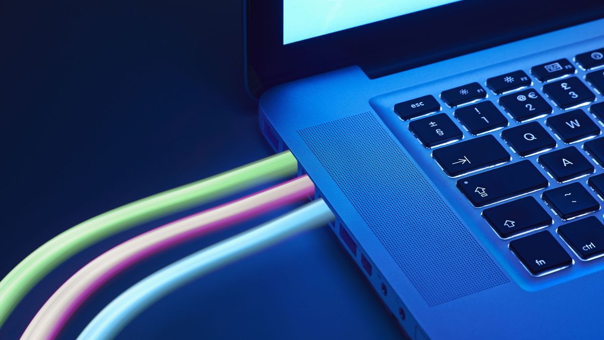 Colourful cables connected to a laptop symbolising broadband connectivity