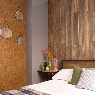 bedroom with wood and cork cladding and bed with designed cushion