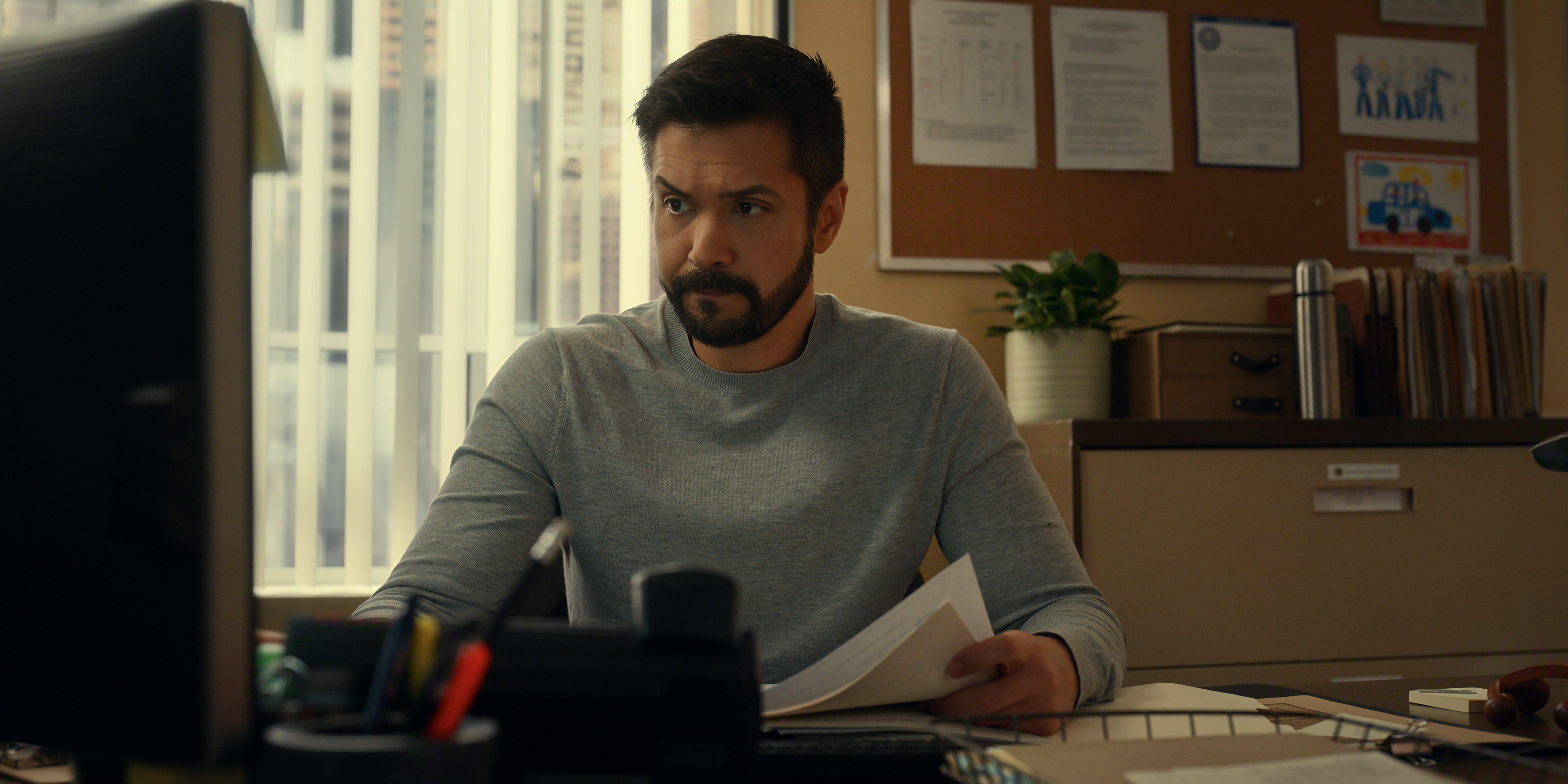 Marco Grazzini as Mike Valenzuela in Episode #705 of Virgin River Season 7 working at a computer holding files