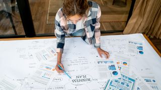 A woman working on her business plan on a large desk