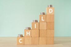Ascending stacks of wooden blocks with "child" written on them, and coins