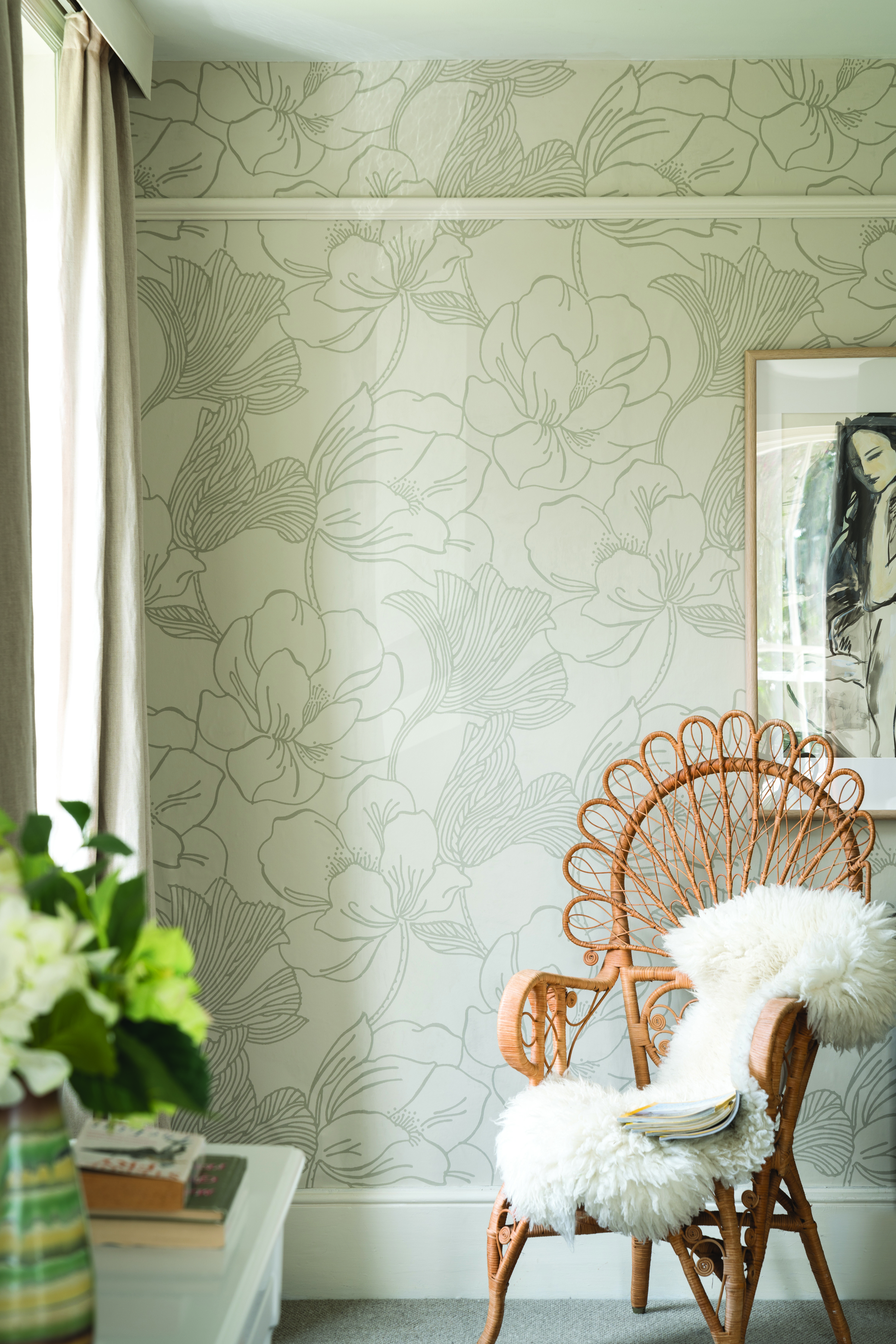 Light green floral wallpaper with framed print and jute armchair