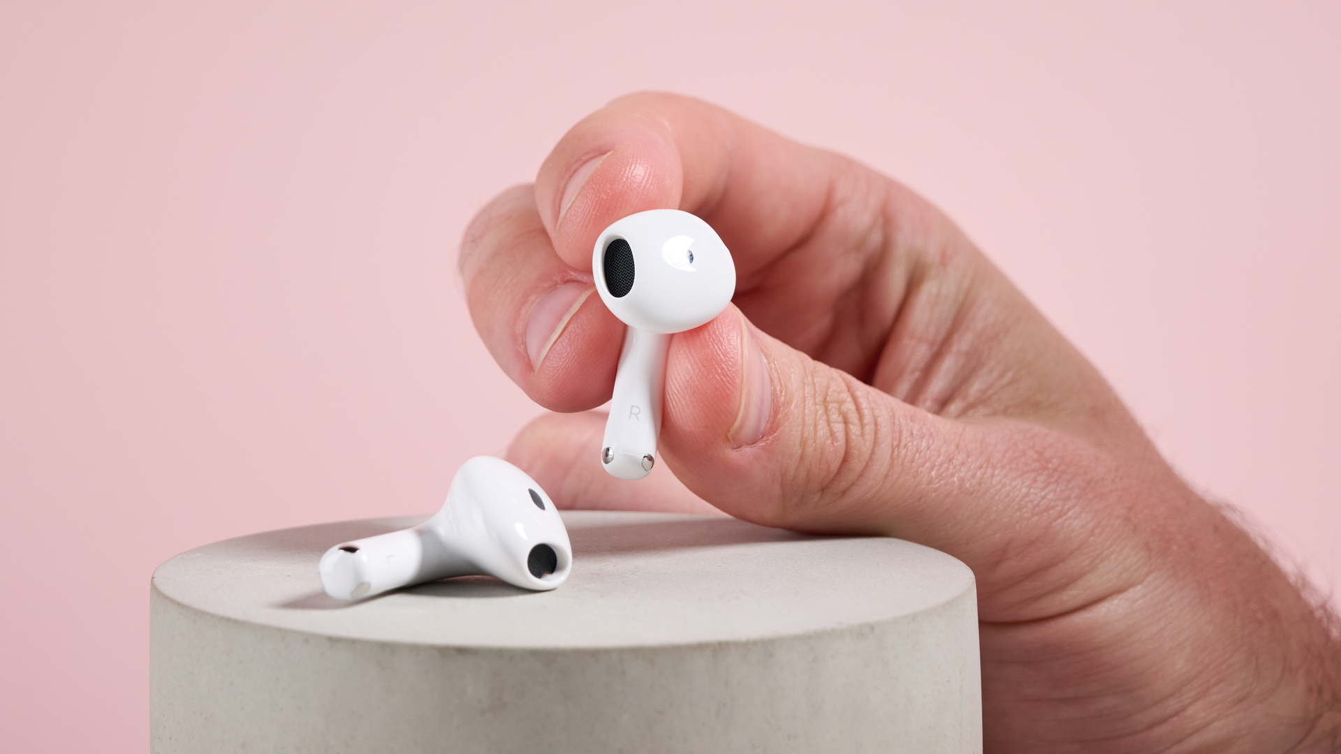 AirPods 4 with Active Noise Cancellation earbuds held in a man's hand