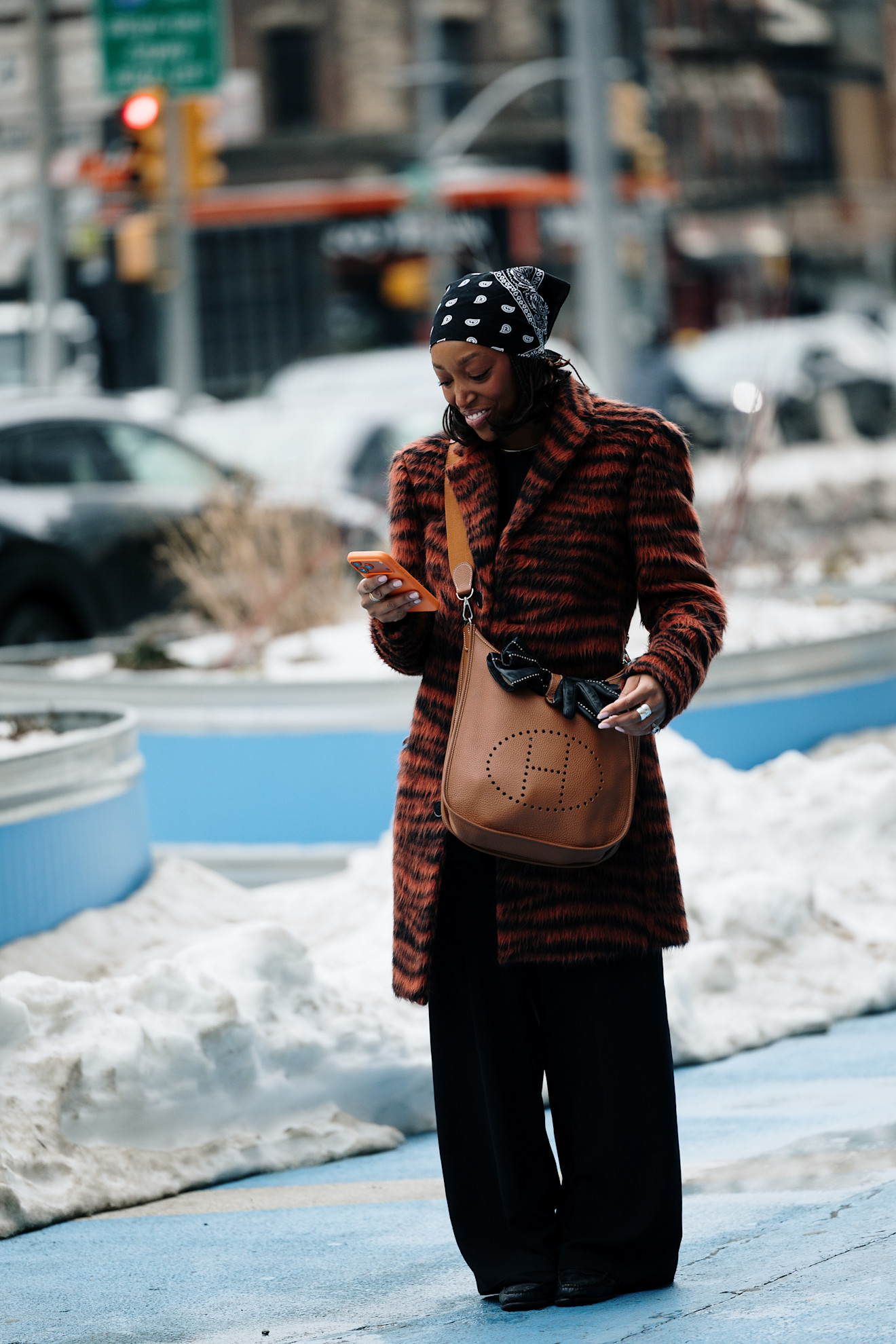 a woman wears a printed coat during fashion week.