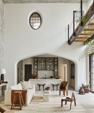 Family room with white walls and sofa overlooking the kitchen through an archway