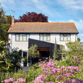 Rear of detached house with angled contemporary extension with black cladding