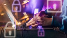 Female hands typing on a laptop in neon light. A lock as a symbol of cybersecurity on a foreground.