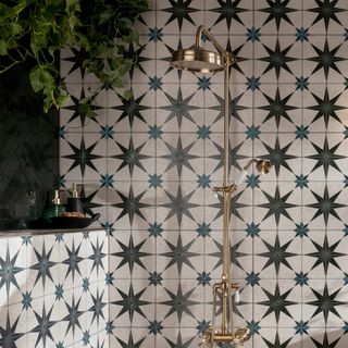 shower with star design tiles and gold shower fittings