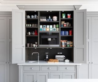 grey butler pantry unit with doors open showing contents