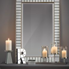 room with mirrored letters near silver wall and white candles