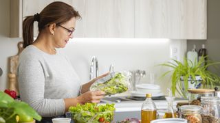 Mature woman looking at nutritional information on the back of a plastic packed salad