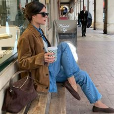 @leasy_inparis wears a tan suede jacket, denim shirt, blue jeans and brown ballet flats