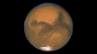 mars appears dusty red with white patch at the bottom.