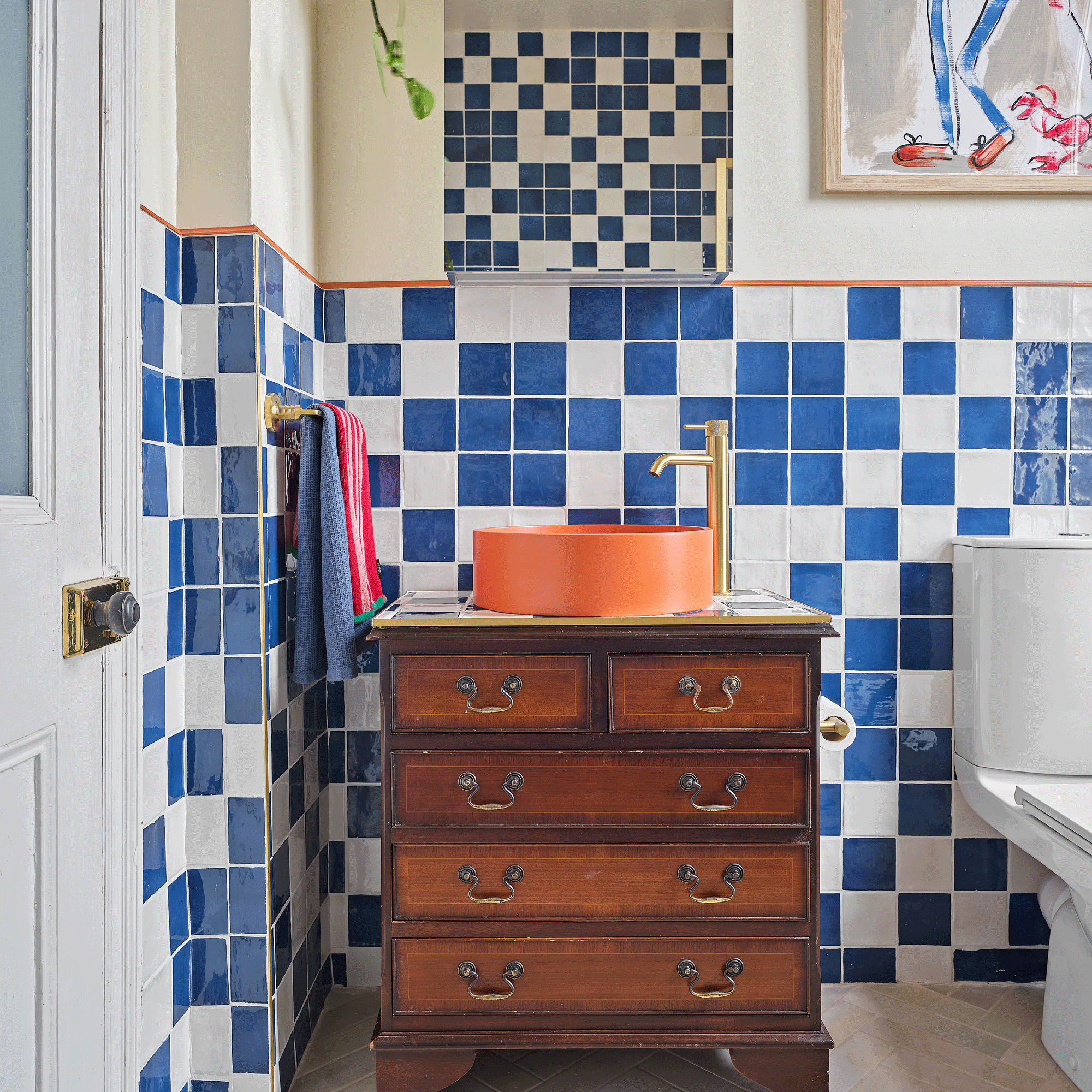 an orange and blue bathroom with a bright orange contemporary style basin on a vanity made from a vintage chest of drawers