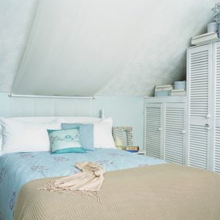 attic bedroom with white wall and white wardrobe