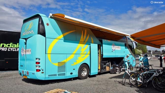A huge awning is hung off the side of the Astana team bus